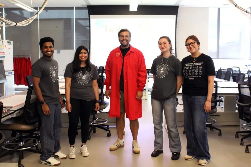 Five members of the Mehta Lab standing together in a teaching lab