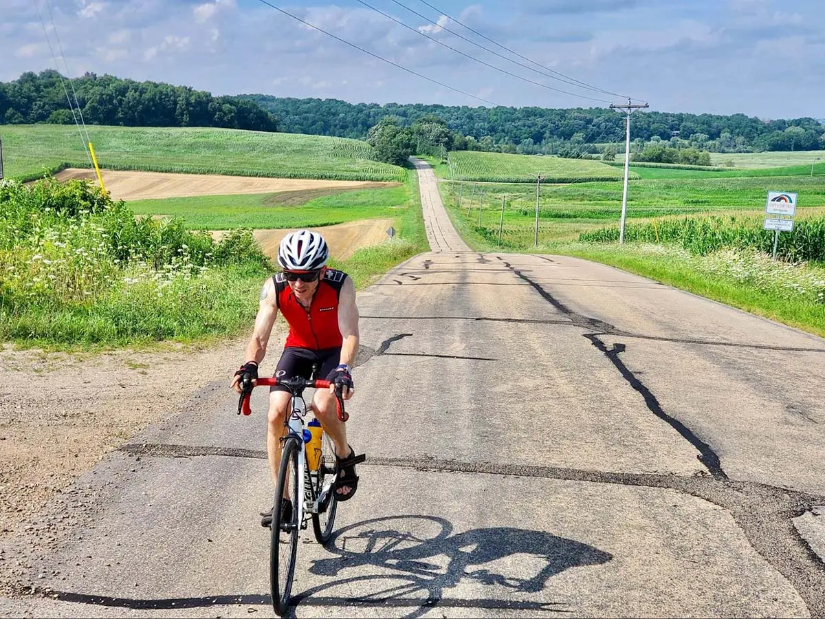 Image of Todd T cycling through a cinematic countryside road.
